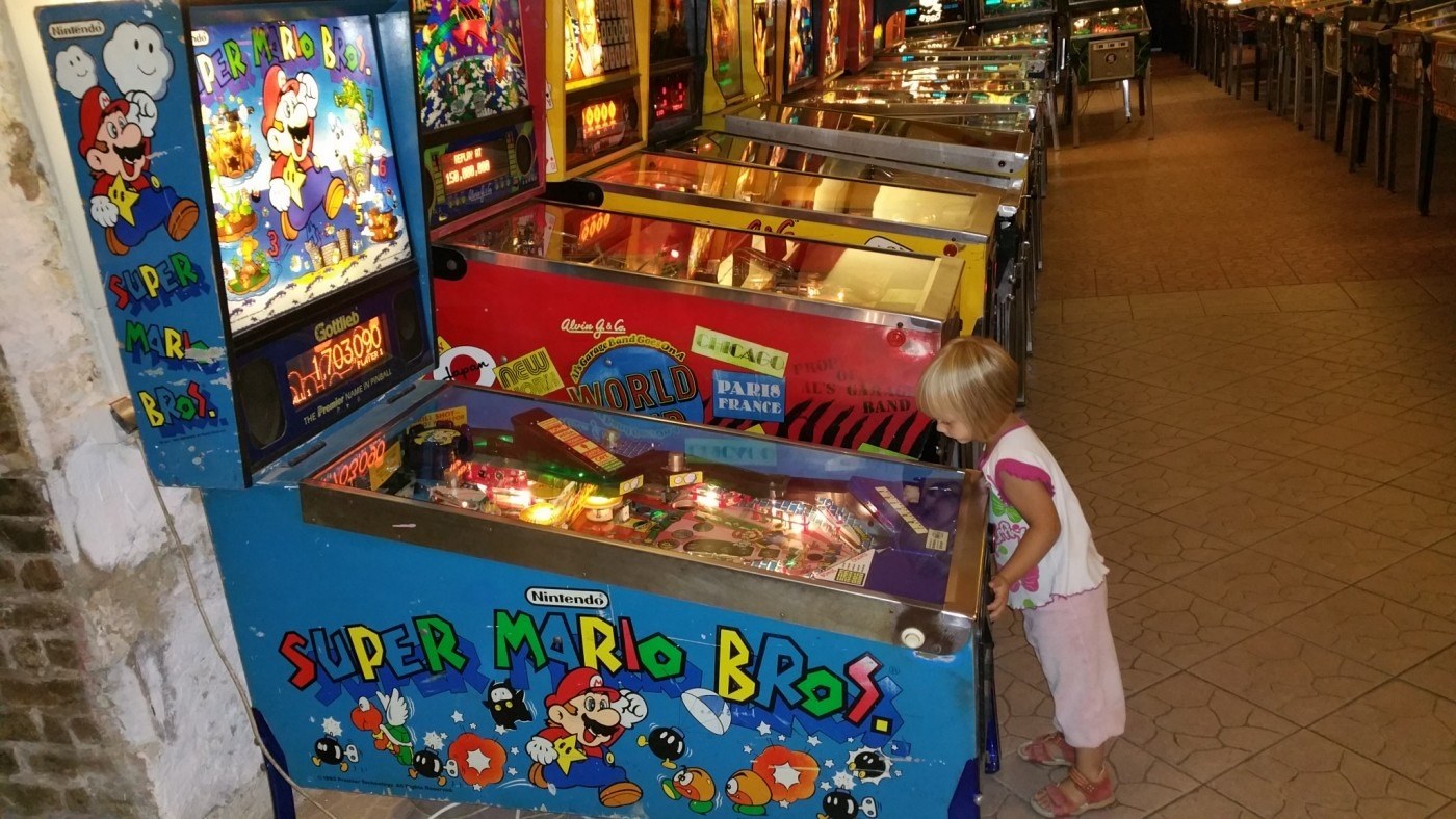 cute little girl playing pinball